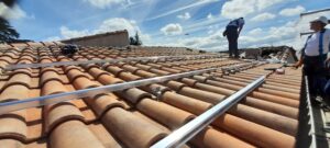 pose des rails servant à fixer les panneaux photovoltaïques sur la toiture