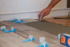 Pose de carrelage au sol dans une maison par un artisan