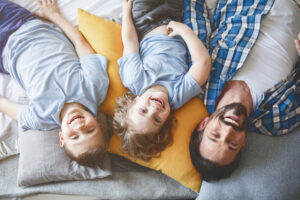 un père et ses deux enfants heureux dans leur maison