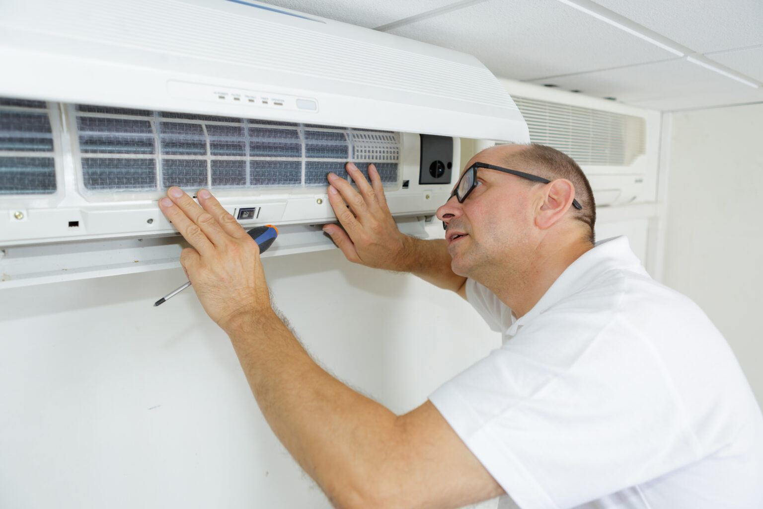 Homme installant une ventilation mécanique contrôlée (VMC)